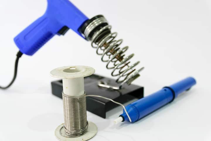 A blue soldering iron, coil, and spool for DIY LED lighting projects.