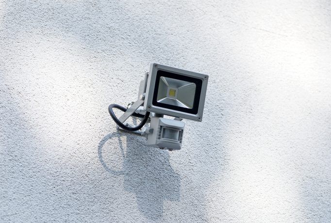 A wall-mounted LED floodlight with motion sensor for outdoor lighting.