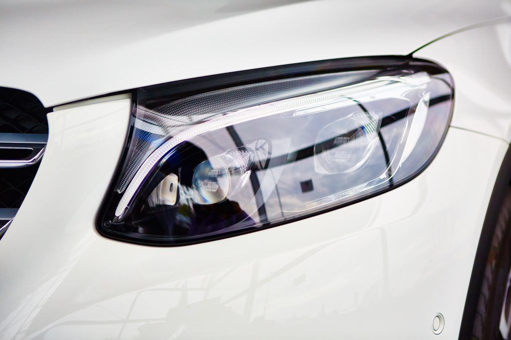 Close-up of a car's modern LED headlight design with reflective surfaces.