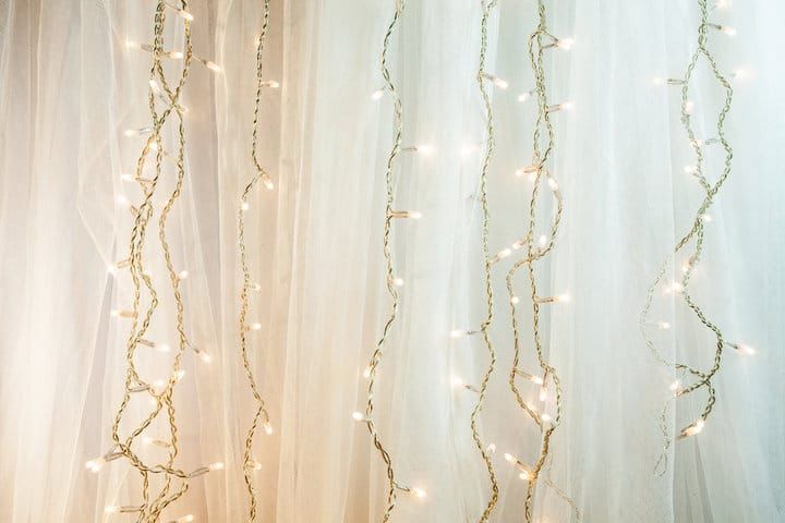 Warm white LED string lights hanging against a soft fabric backdrop.