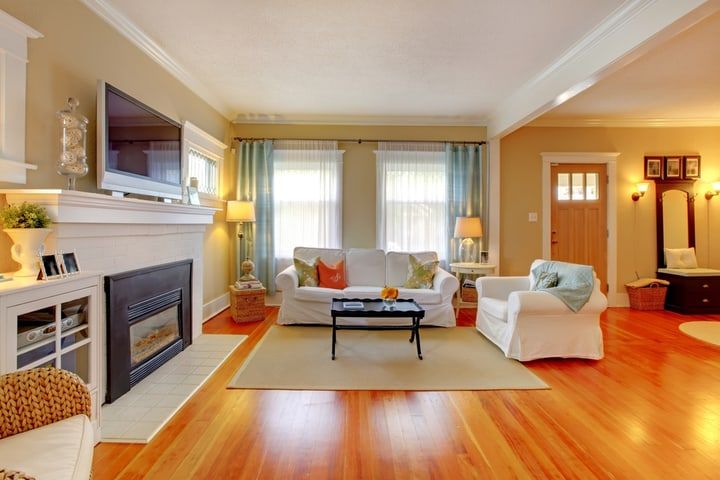 Cozy living room with bright windows, comfortable furniture, and warm lighting.
