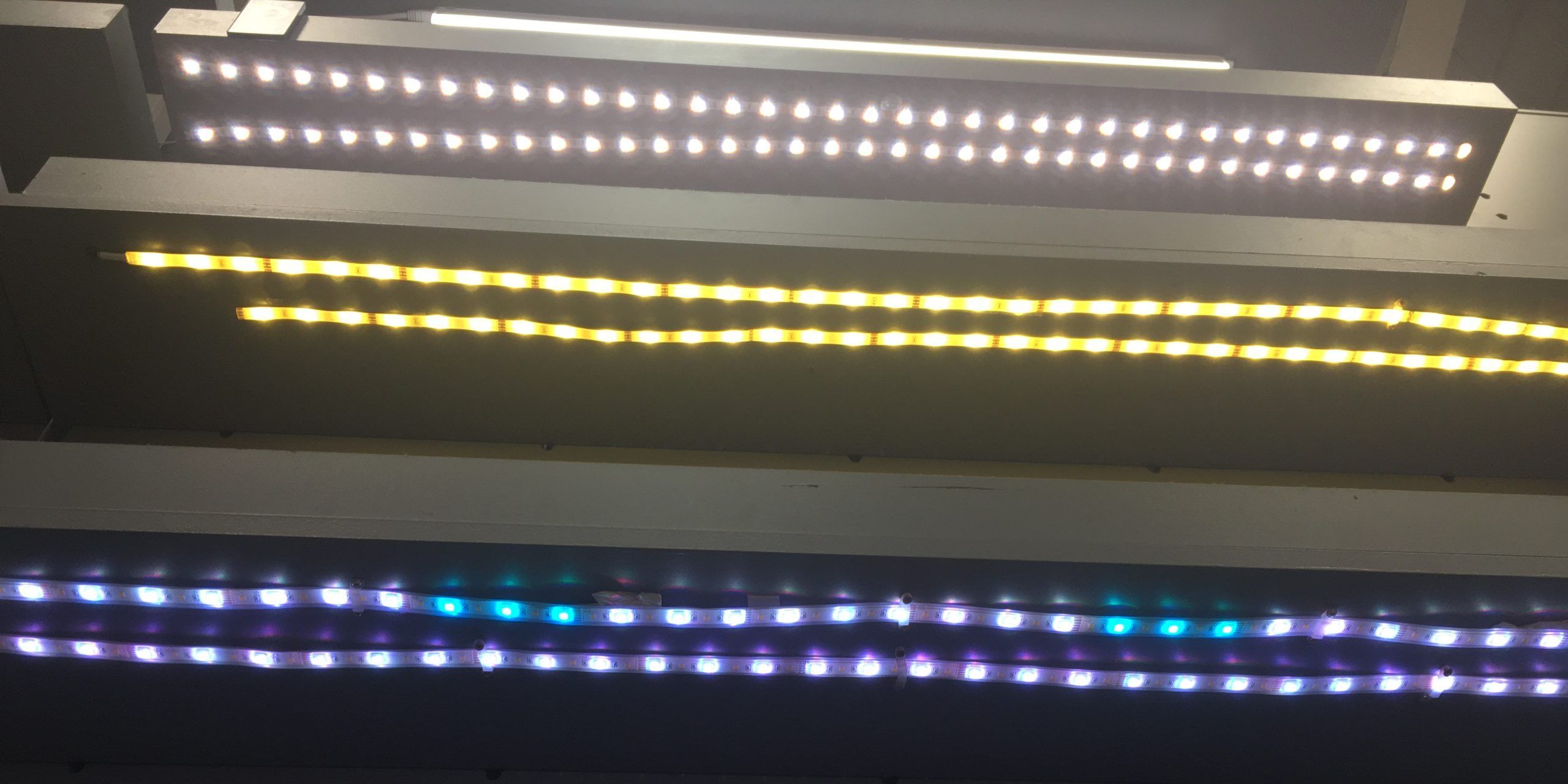 Three rows of LED strip lights showing different colors and brightness levels.