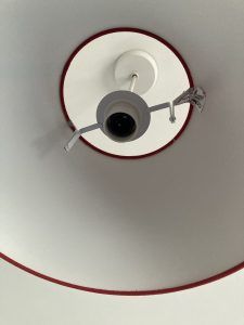 View of a ceiling light fixture with a circular design and red trim.
