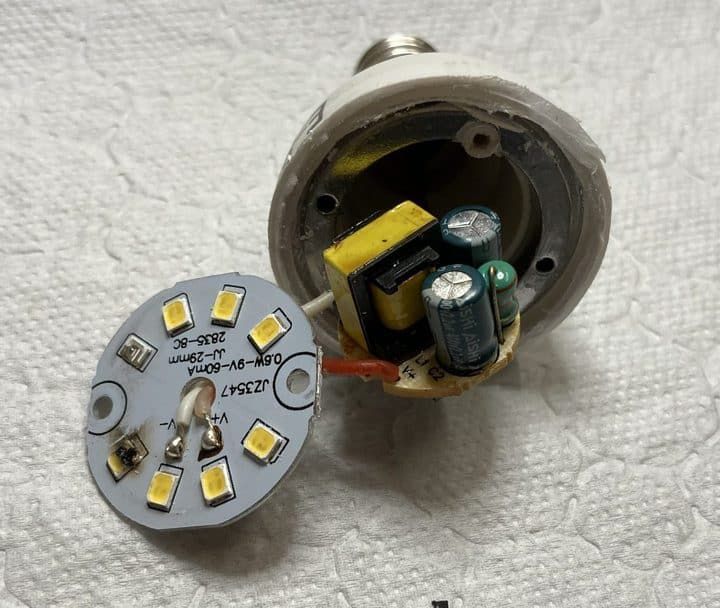 Disassembled LED bulb showing internal components and circuit board.