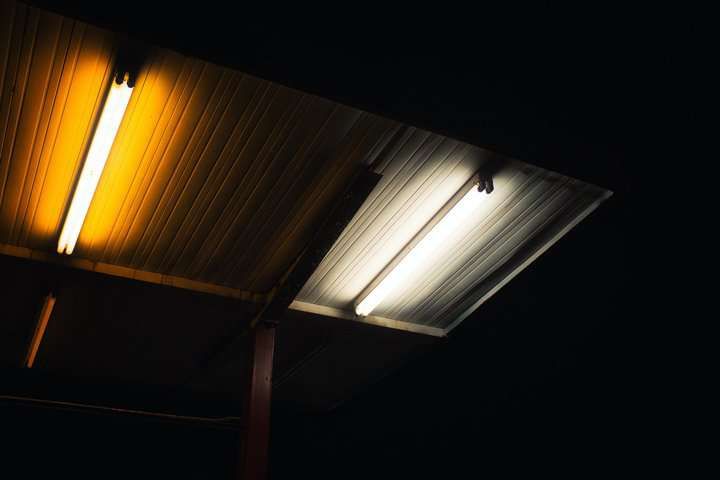 Two fluorescent LED lights casting warm and cool light on a ceiling.