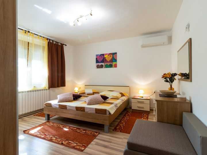 Brightly lit modern bedroom featuring a cozy bed and decorative elements.