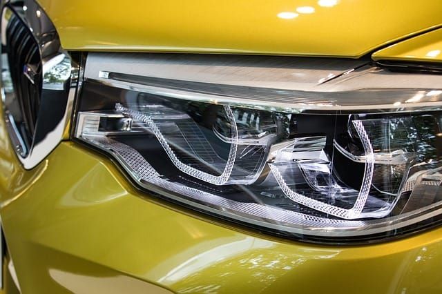 Close-up of an LED car headlight on a yellow vehicle.