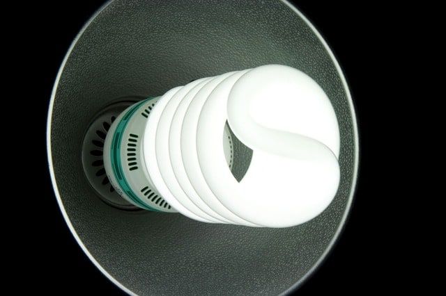 A spiral LED bulb inside a decorative lamp shade, providing soft white light.