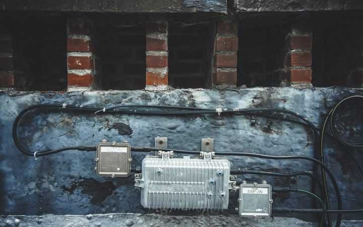 Close-up of a wall with wires and electrical components mounted on it.