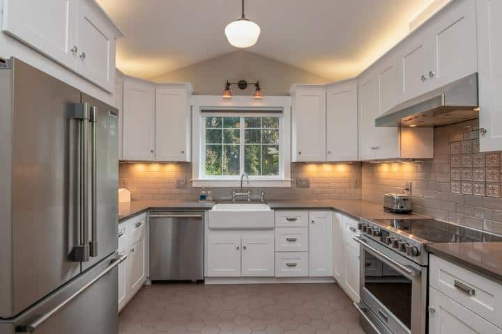Bright modern kitchen featuring LED lighting and stainless steel appliances.