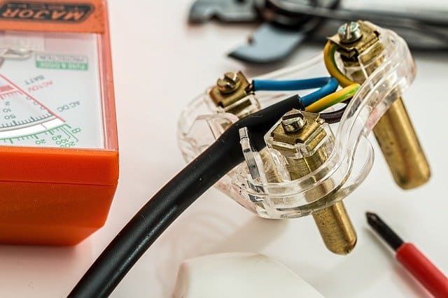 Close-up of electrical connectors and a multimeter on a work surface.