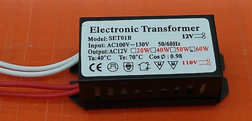 An electronic transformer with input and output specifications printed on it.