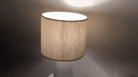 A modern LED table lamp with a cylindrical shade casting soft light.