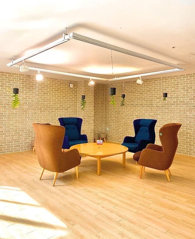 Bright indoor seating area with modern armchairs and wooden table.
