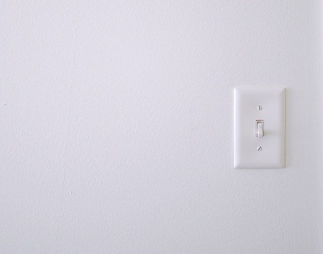 Simple light switch on a plain white wall with no additional features.