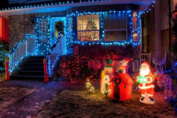 A festive home decorated with colorful LED lights and holiday figures.