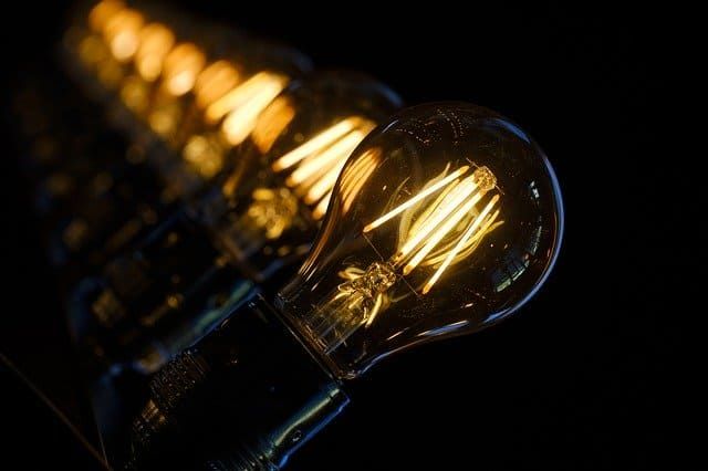 Close-up of illuminated vintage-style light bulbs on a dark background.