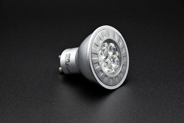 A silver LED light bulb with multiple glowing diodes on a dark background.