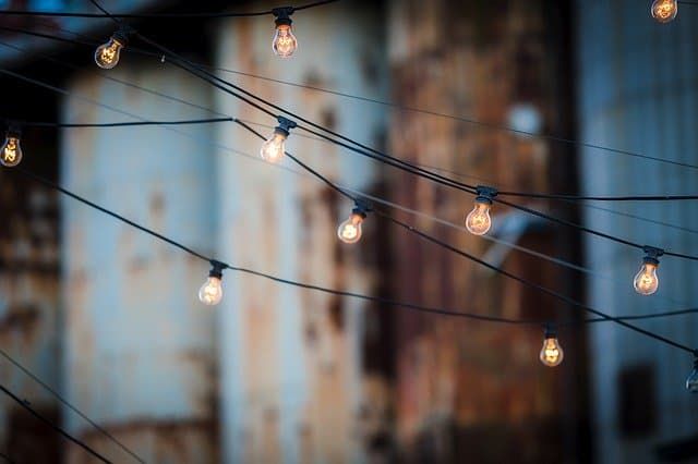 String lights hang above, illuminated against a weathered background.