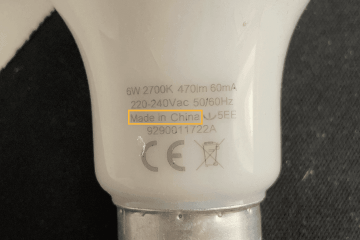 Close-up of an LED bulb base displaying specifications and origin label.
