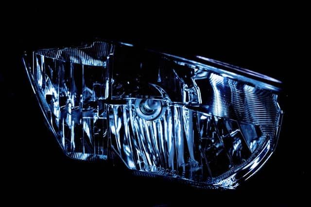 Close-up of a glossy LED headlight showing intricate reflective details.