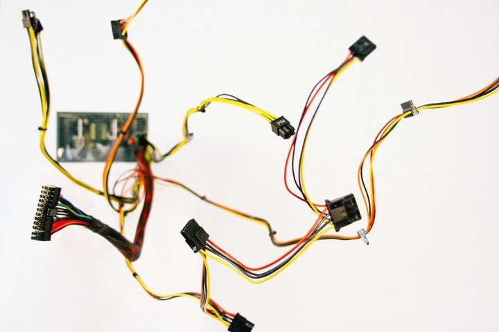 Colorful wires and a circuit board arranged against a white background.