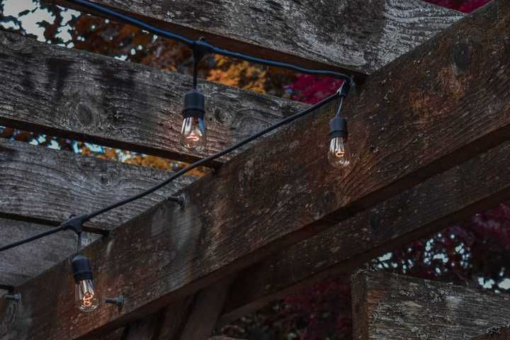 String lights hang gracefully above a rustic wooden pergola.