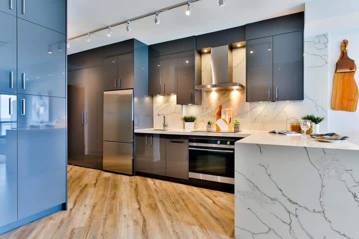 Modern kitchen featuring sleek cabinets, a marble countertop, and under-cabinet LED lights.