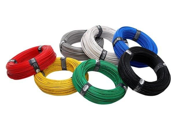 Colorful rolls of electrical wire in various shades for lighting projects.